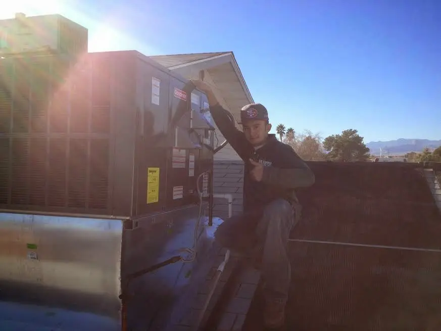 HVAC technician performing AC Tune-Up on a rooftop unit in Alachua